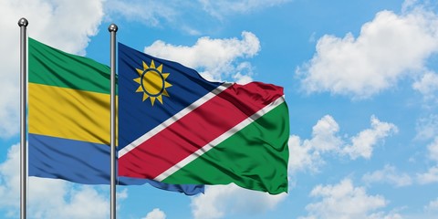 Gabon and Namibia flag waving in the wind against white cloudy blue sky together. Diplomacy concept, international relations.