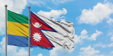Gabon and Nepal flag waving in the wind against white cloudy blue sky together. Diplomacy concept, international relations.