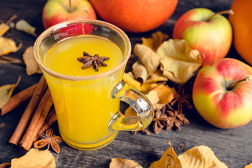 Autumn hot and spicy drink with pumpkin and orange juice on the rustic background. Selective focus. Shallow depth of field.