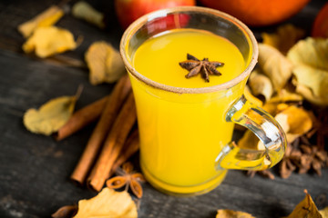Autumn hot and spicy drink with pumpkin and orange juice on the rustic background. Selective focus. Shallow depth of field.