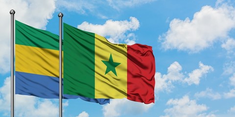 Gabon and Senegal flag waving in the wind against white cloudy blue sky together. Diplomacy concept, international relations.