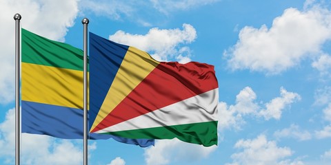 Gabon and Seychelles flag waving in the wind against white cloudy blue sky together. Diplomacy concept, international relations.
