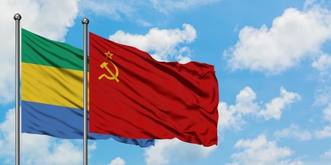 Gabon and Soviet Union flag waving in the wind against white cloudy blue sky together. Diplomacy...