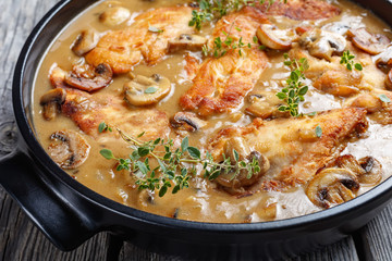 Chicken Marsala in a black ceramic dish