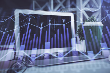 Stock market graph on background with desk and personal computer. Multi exposure. Concept of financial analysis.