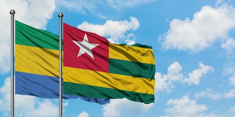 Gabon and Togo flag waving in the wind against white cloudy blue sky together. Diplomacy concept, international relations.