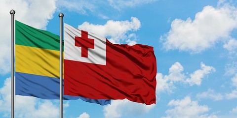 Gabon and Tonga flag waving in the wind against white cloudy blue sky together. Diplomacy concept,...