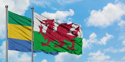 Gabon and Wales flag waving in the wind against white cloudy blue sky together. Diplomacy concept, international relations.