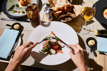 cropped view of woman eating delicious eggplant caviar in restaurant
