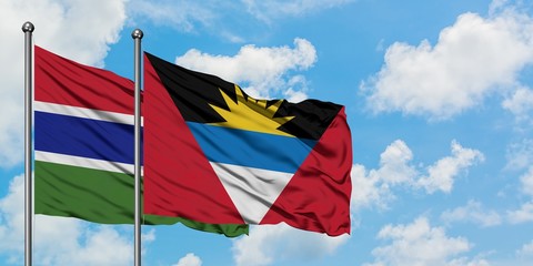 Gambia and Antigua and Barbuda flag waving in the wind against white cloudy blue sky together. Diplomacy concept, international relations.