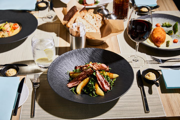 delicious warm salad with meat, arugula, potato served on table in restaurant