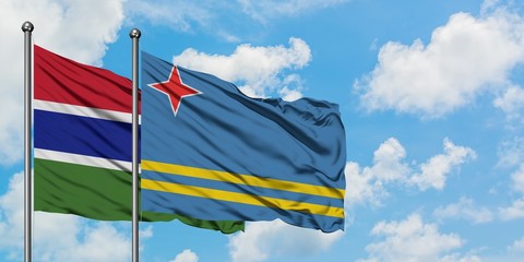 Gambia and Aruba flag waving in the wind against white cloudy blue sky together. Diplomacy concept, international relations.