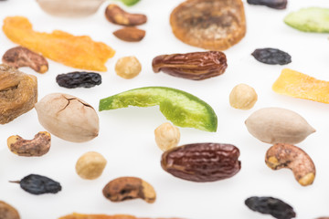 close up view of tasty assorted nuts, dried fruits and candied fruit isolated on white