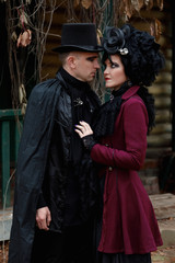 Passionate young couple dressed in old fashioned vampire style clothes outdoors
