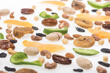 close up view of tasty assorted nuts, dried fruits and candied fruit isolated on white