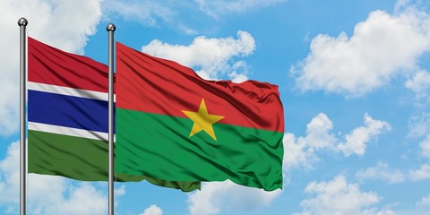 Gambia and Burkina Faso flag waving in the wind against white cloudy blue sky together. Diplomacy concept, international relations.