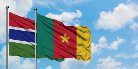 Gambia and Cameroon flag waving in the wind against white cloudy blue sky together. Diplomacy concept, international relations.