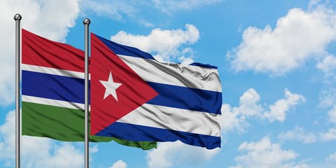 Gambia and Cuba flag waving in the wind against white cloudy blue sky together. Diplomacy concept, international relations.