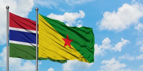 Gambia and French Guiana flag waving in the wind against white cloudy blue sky together. Diplomacy concept, international relations.