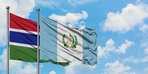Gambia and Guatemala flag waving in the wind against white cloudy blue sky together. Diplomacy concept, international relations.