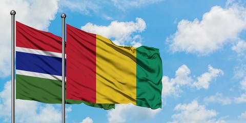 Gambia and Guinea flag waving in the wind against white cloudy blue sky together. Diplomacy concept, international relations.
