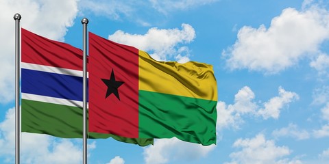 Gambia and Guinea Bissau flag waving in the wind against white cloudy blue sky together. Diplomacy concept, international relations.