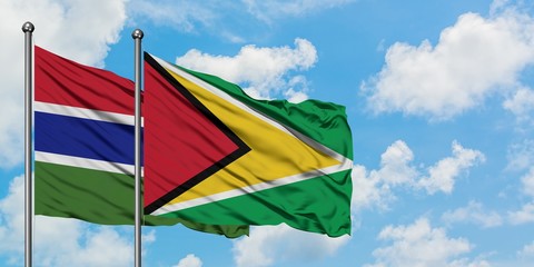 Gambia and Guyana flag waving in the wind against white cloudy blue sky together. Diplomacy concept, international relations.