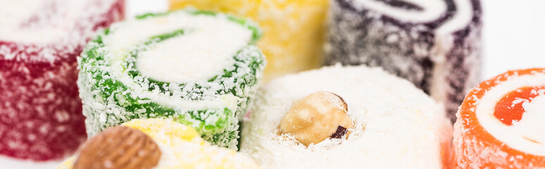 close up view of assorted delicious turkish delight in coconut flakes isolated on white, panoramic shot