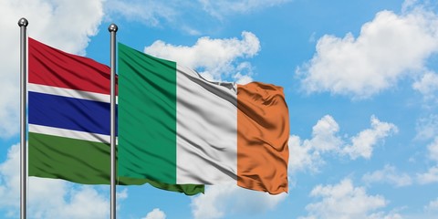 Gambia and Ireland flag waving in the wind against white cloudy blue sky together. Diplomacy concept, international relations.