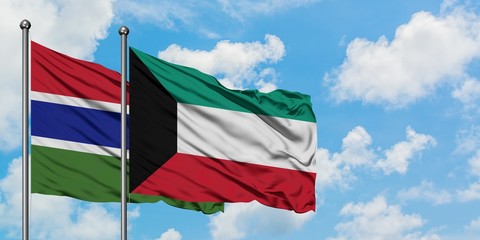 Gambia and Kuwait flag waving in the wind against white cloudy blue sky together. Diplomacy concept, international relations.