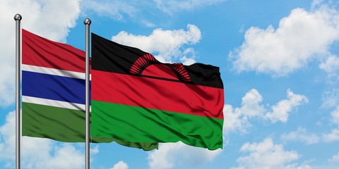 Gambia and Malawi flag waving in the wind against white cloudy blue sky together. Diplomacy concept, international relations.