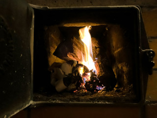 Fire in the stove. Stove heating in an old house. Firewood burns and heats a wooden house.