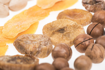close up view of dried mango slices, figs and macadamia nuts isolated on white