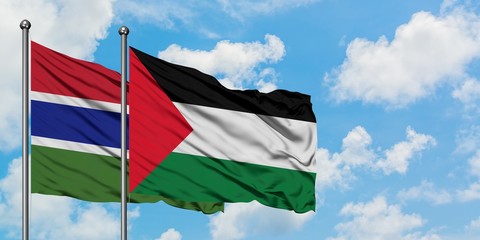 Gambia and Palestine flag waving in the wind against white cloudy blue sky together. Diplomacy concept, international relations.