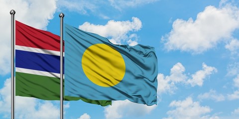 Gambia and Palau flag waving in the wind against white cloudy blue sky together. Diplomacy concept, international relations.