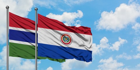 Gambia and Paraguay flag waving in the wind against white cloudy blue sky together. Diplomacy concept, international relations.