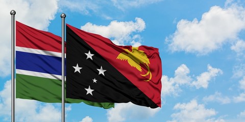 Gambia and Papua New Guinea flag waving in the wind against white cloudy blue sky together. Diplomacy concept, international relations.