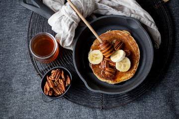 Pancakes with banana, walnuts and honey. Morning concept
