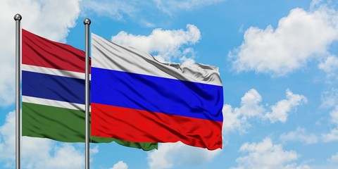 Gambia and Russia flag waving in the wind against white cloudy blue sky together. Diplomacy concept, international relations.