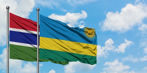Gambia and Rwanda flag waving in the wind against white cloudy blue sky together. Diplomacy concept, international relations.