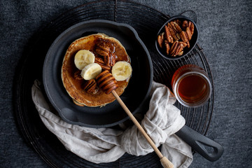 Pancakes with banana, walnuts and honey. Morning concept