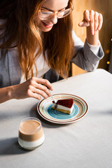 happy beautiful woman eating cake with coffee in cafe