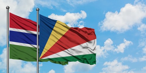 Gambia and Seychelles flag waving in the wind against white cloudy blue sky together. Diplomacy concept, international relations.
