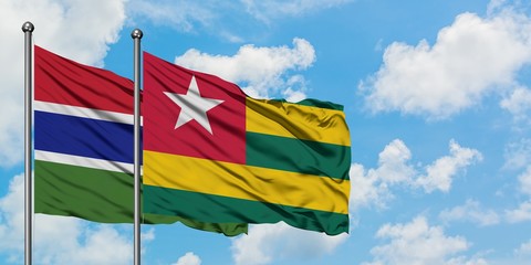 Gambia and Togo flag waving in the wind against white cloudy blue sky together. Diplomacy concept, international relations.