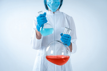 Scientist woman holding medical glass bottle with liquid, making laboratory research