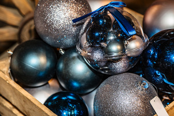 Christmas toys balls lying in wooden box close up