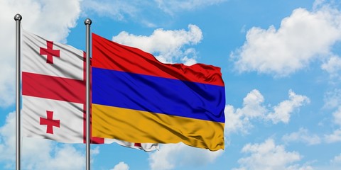 Georgia and Armenia flag waving in the wind against white cloudy blue sky together. Diplomacy concept, international relations.