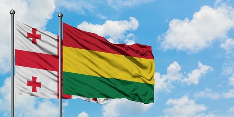 Georgia and Bolivia flag waving in the wind against white cloudy blue sky together. Diplomacy concept, international relations.