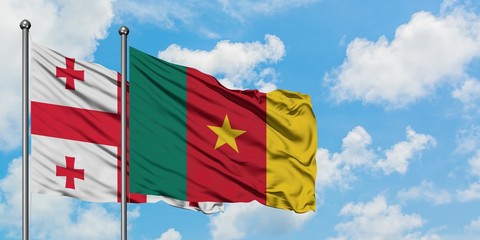 Georgia and Cameroon flag waving in the wind against white cloudy blue sky together. Diplomacy concept, international relations.