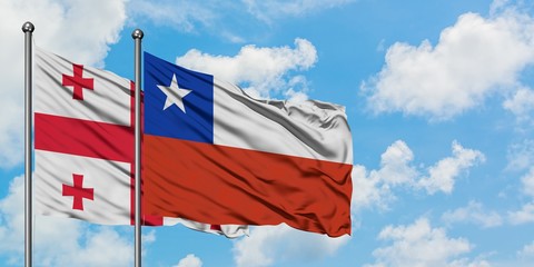 Georgia and Chile flag waving in the wind against white cloudy blue sky together. Diplomacy concept, international relations.